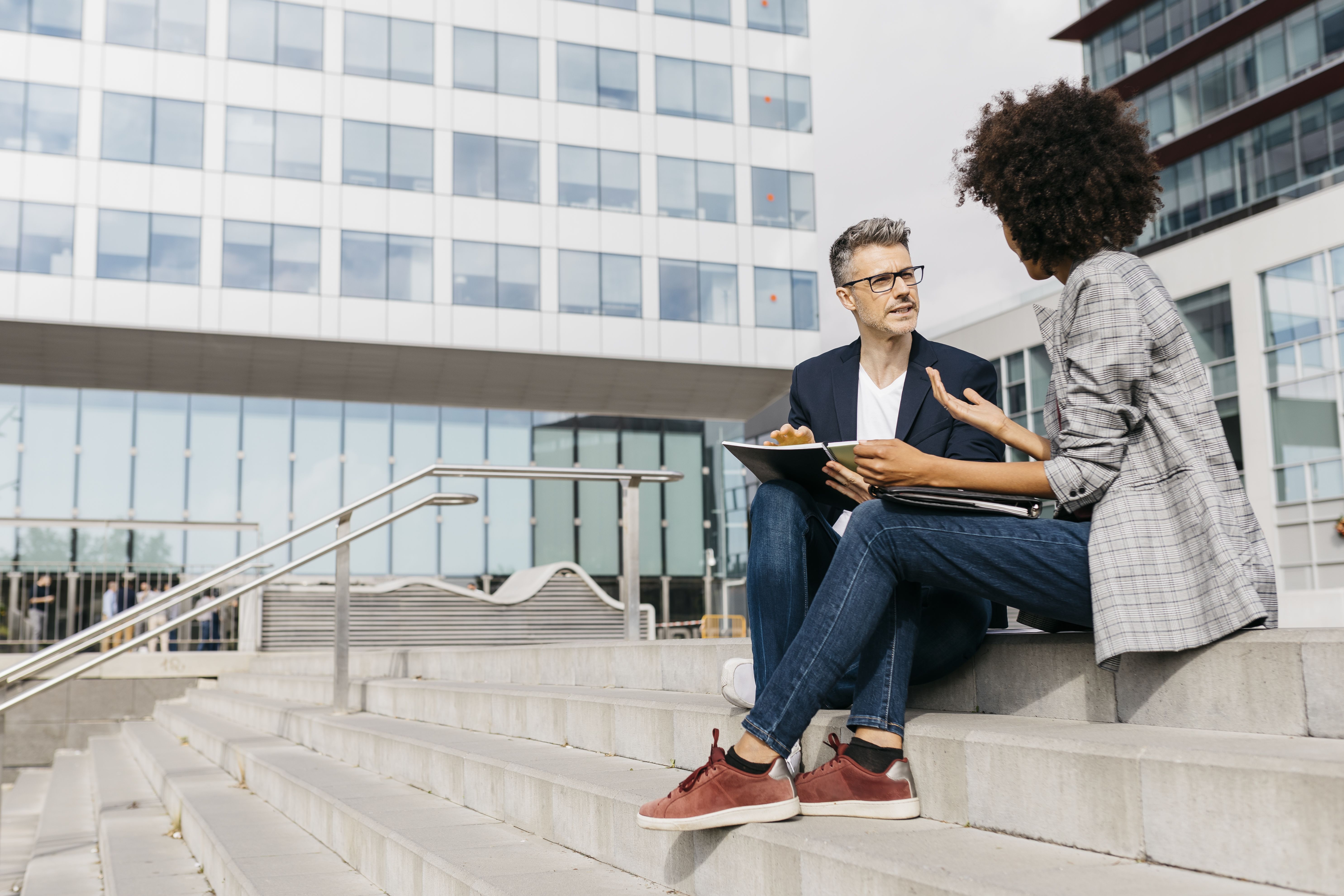 Two colleagues working together outside office building